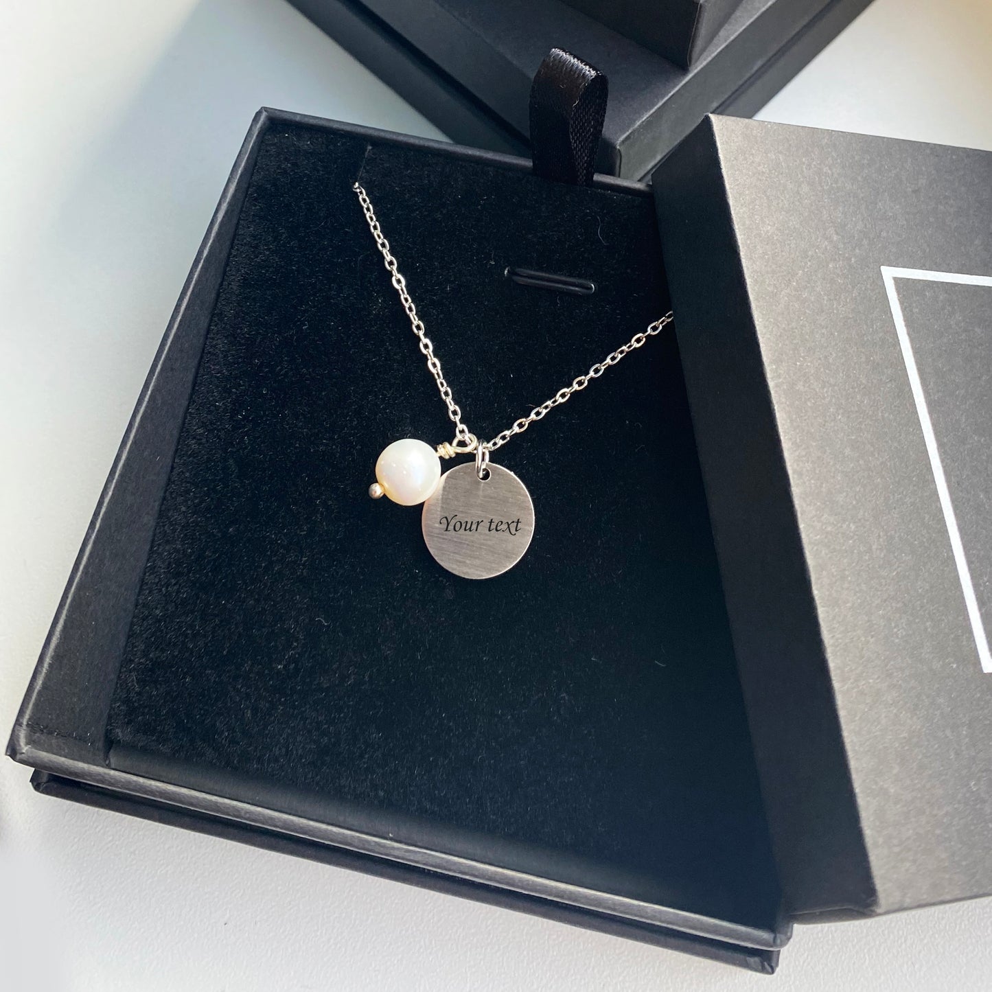 Apsudrabots kulons ar Tavu iegravētu tekstu + pērle