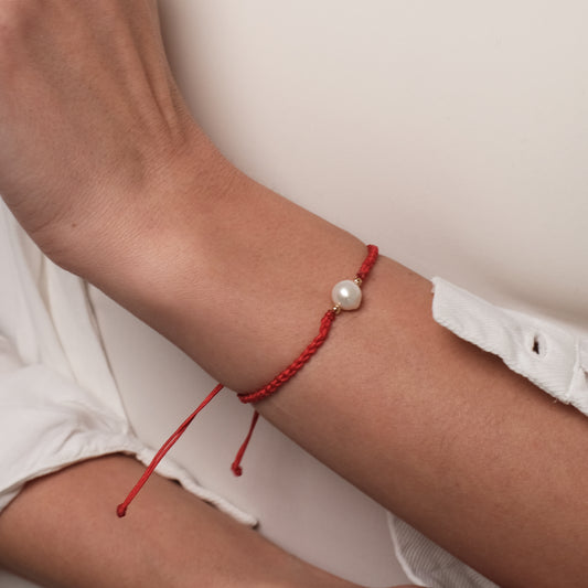 Raudona apyrankė su perlu